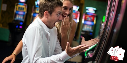 Couple in Casino Winning on Slot Machine