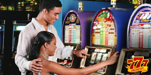 Couple playing slot machine in casino